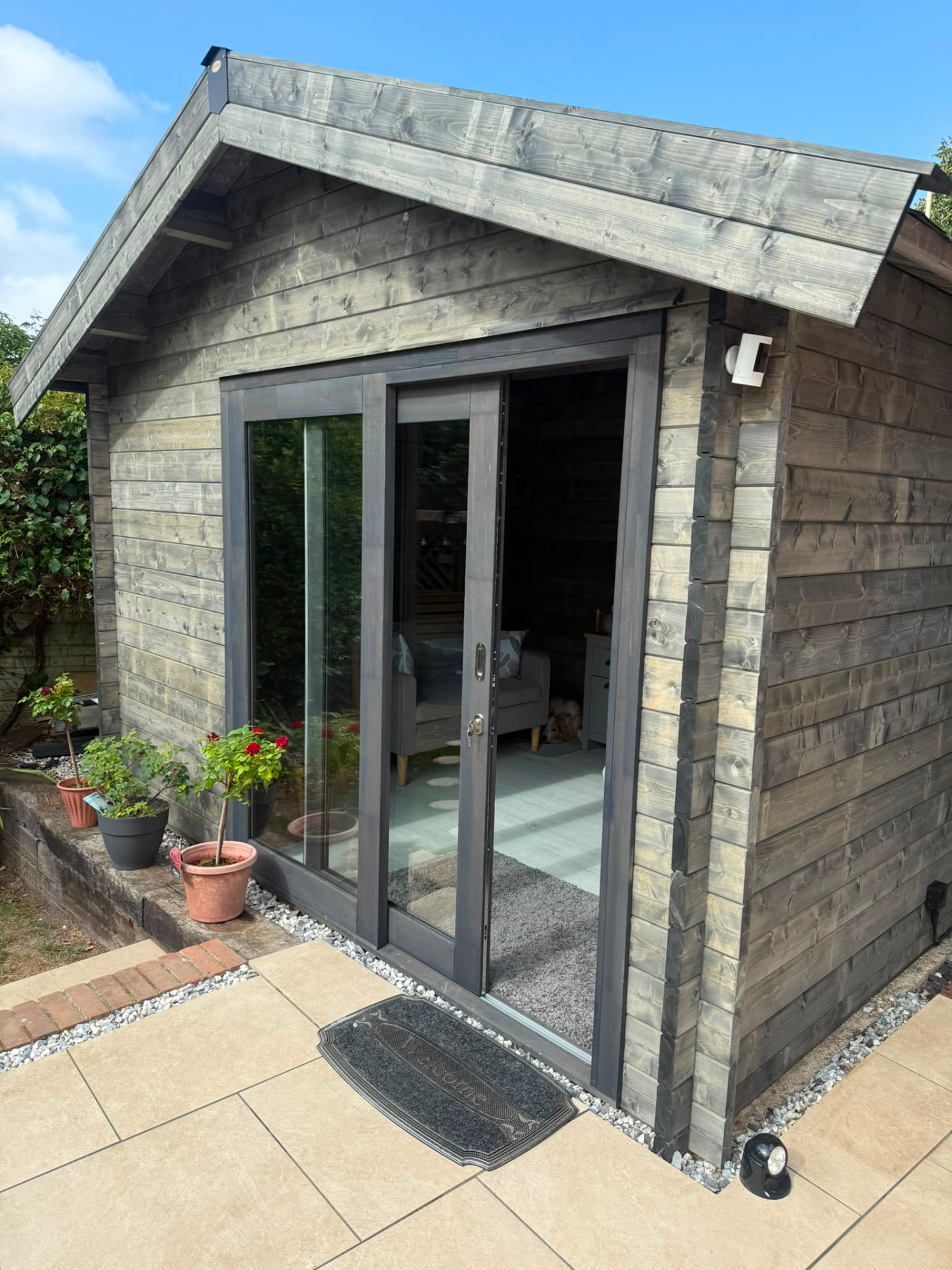 The timber log cabin therapy room with sliding doors open, showing the comfortable interior